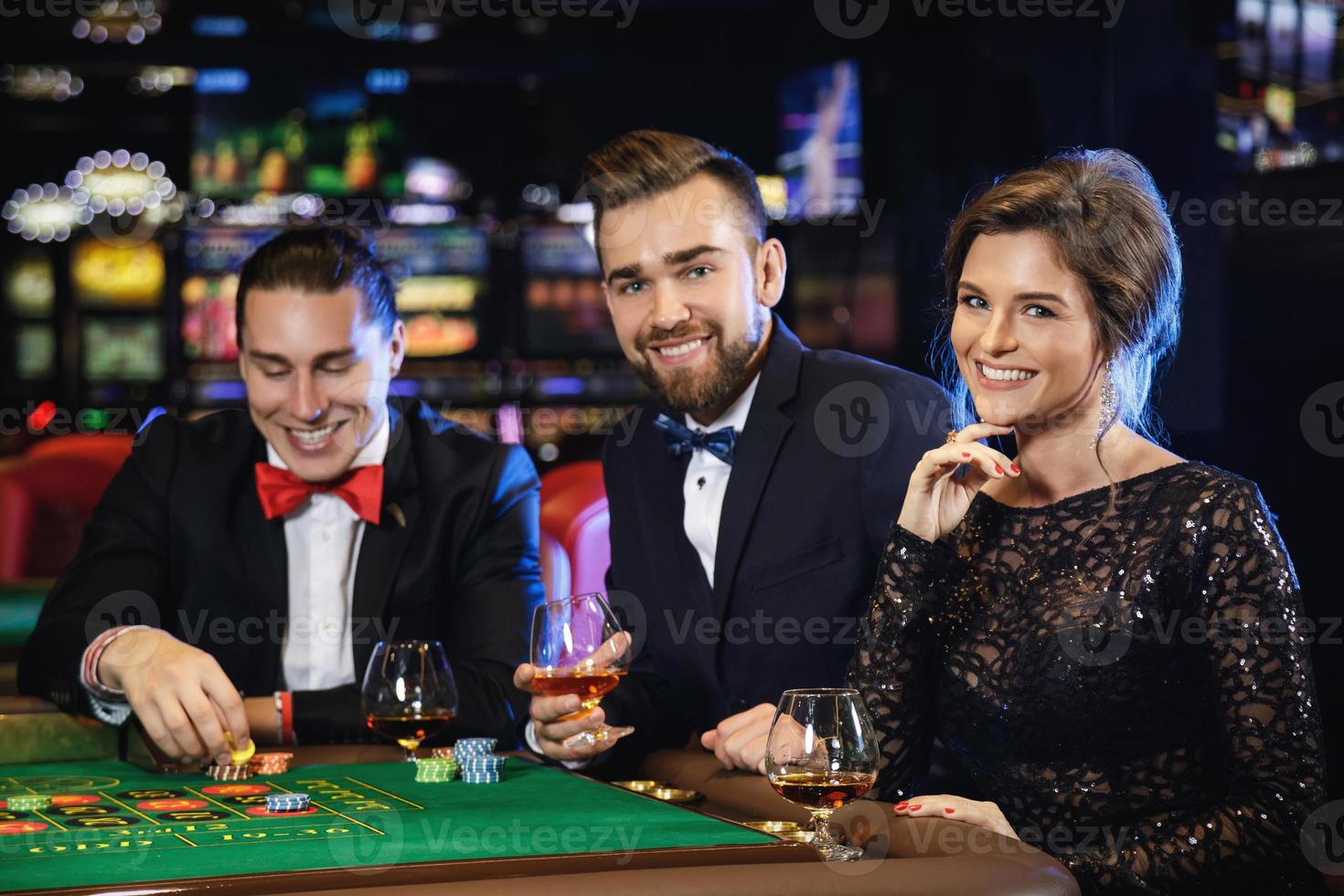 pessoas bonitas e ricas jogando roleta no cassino foto