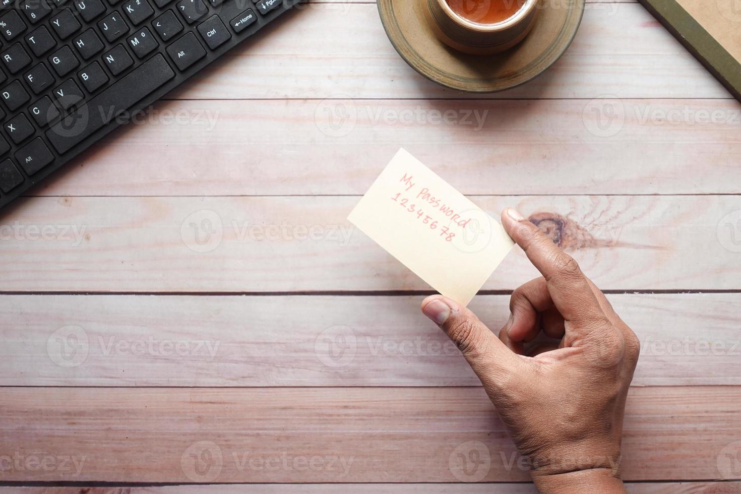 segurando uma mão de cartão escrevendo texto de senha foto