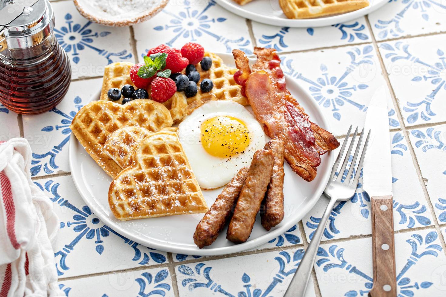 mesa de café da manhã com waffles. ovo frito, bacon e salsicha foto