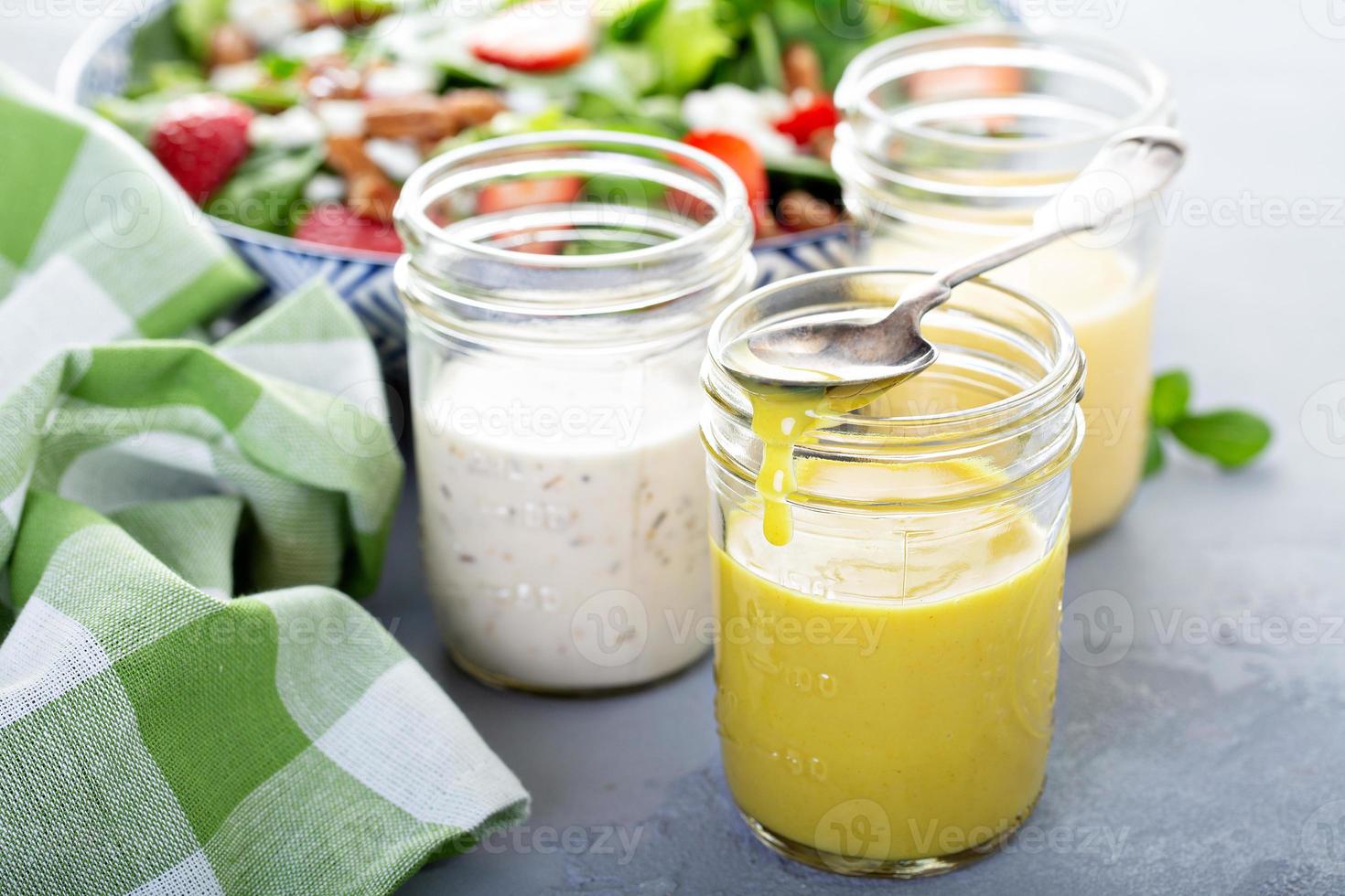 variedade de molhos para salada em potes de vidro foto