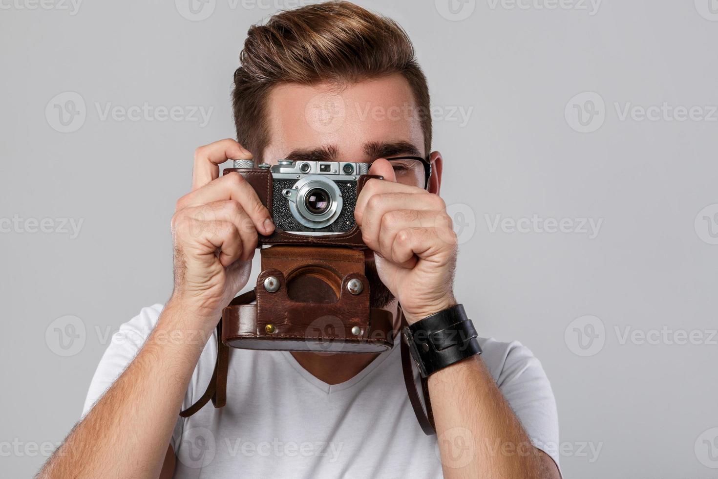 homem fotógrafo com câmera retro em estúdio foto