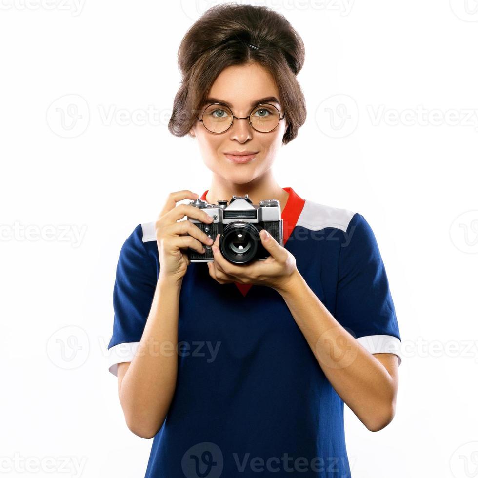 modelo de mulher em look vintage segurando a câmera retrô nas mãos foto