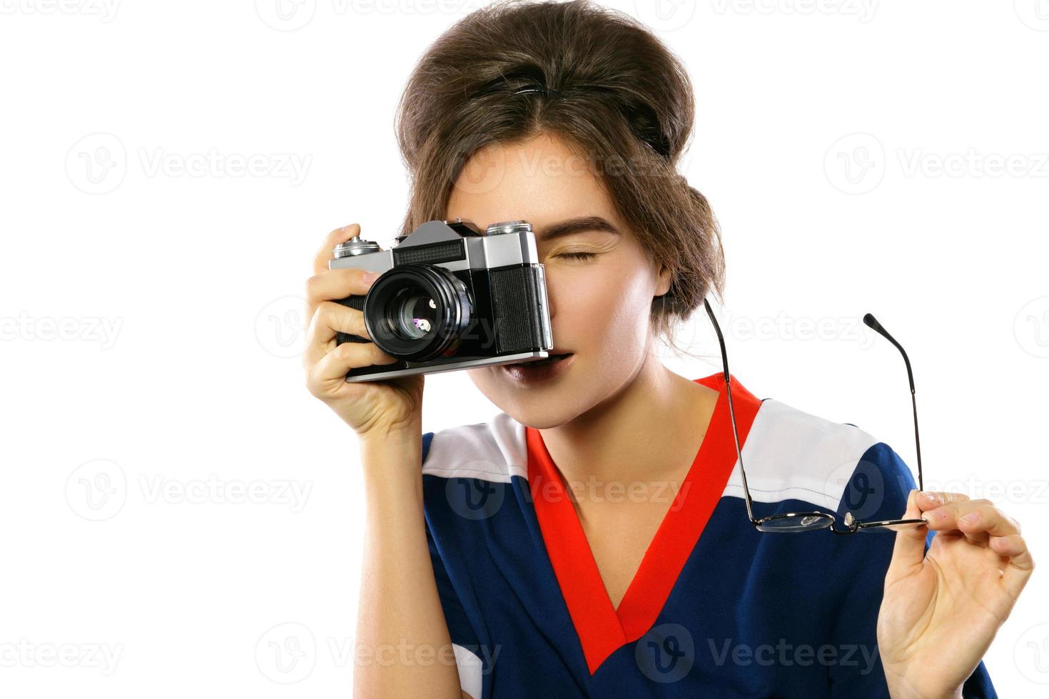 modelo de mulher em look vintage segurando a câmera retrô nas mãos foto