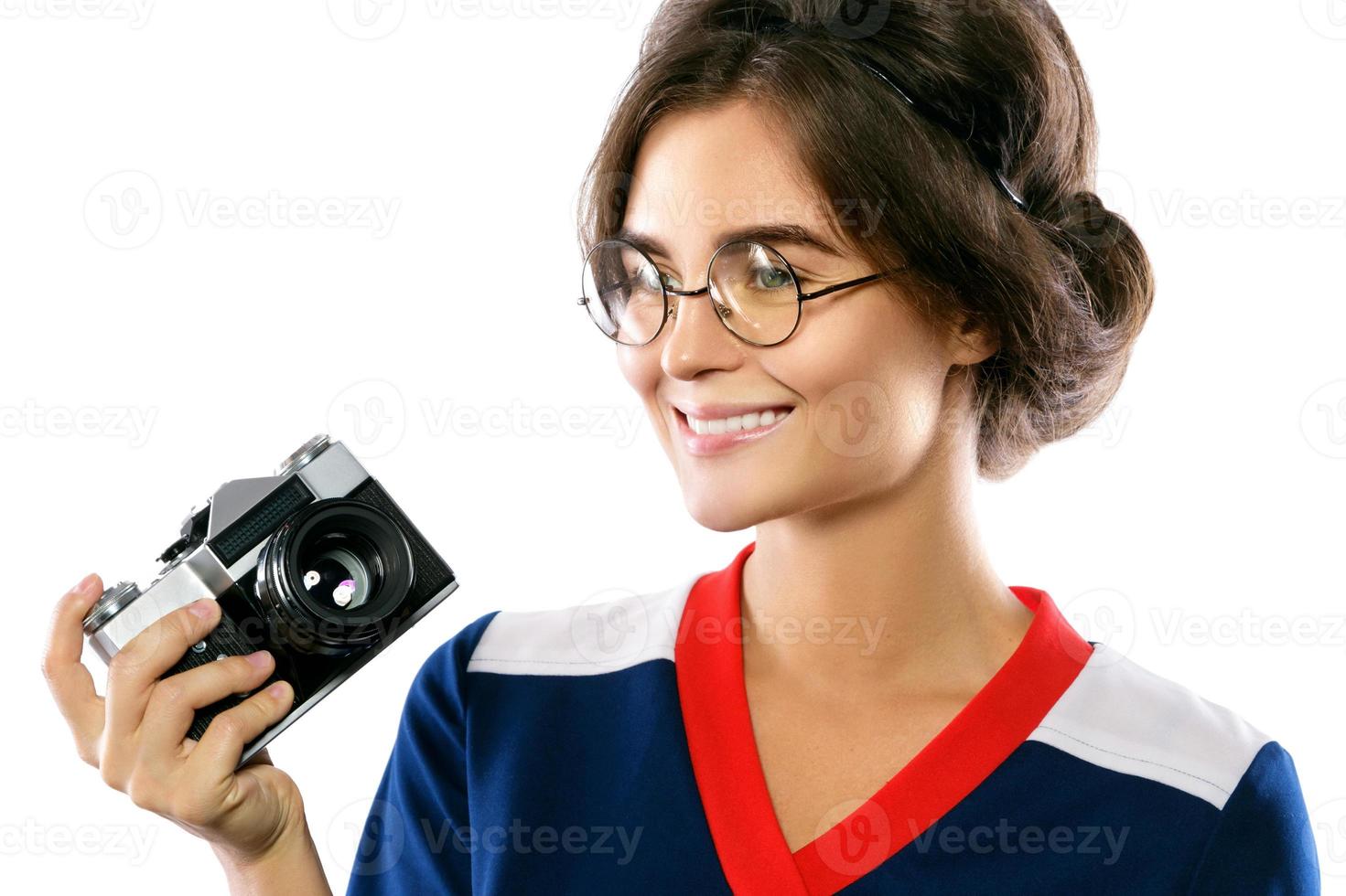 modelo de mulher em look vintage segurando a câmera retrô nas mãos foto