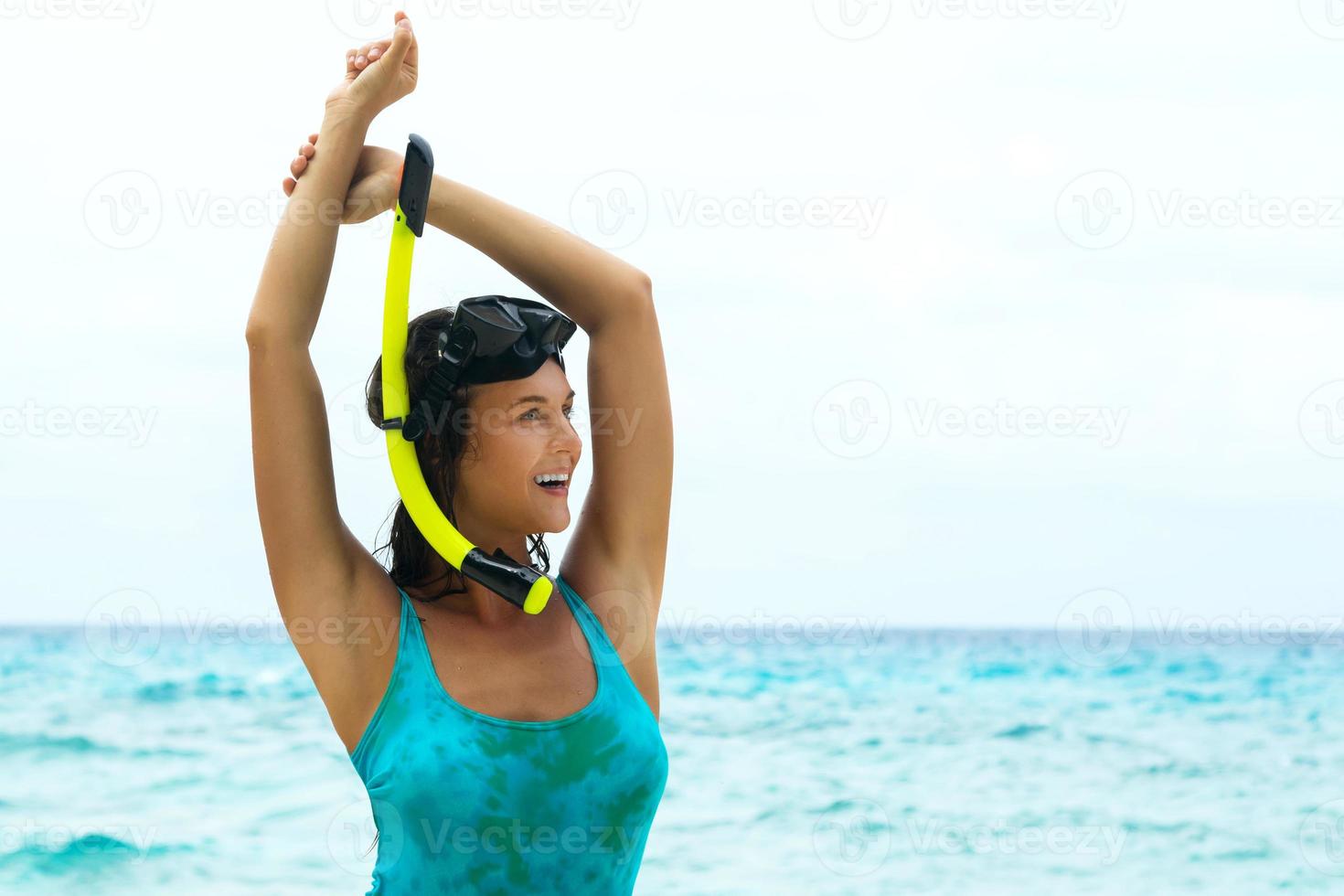 mulher feliz na praia com máscara para mergulho foto