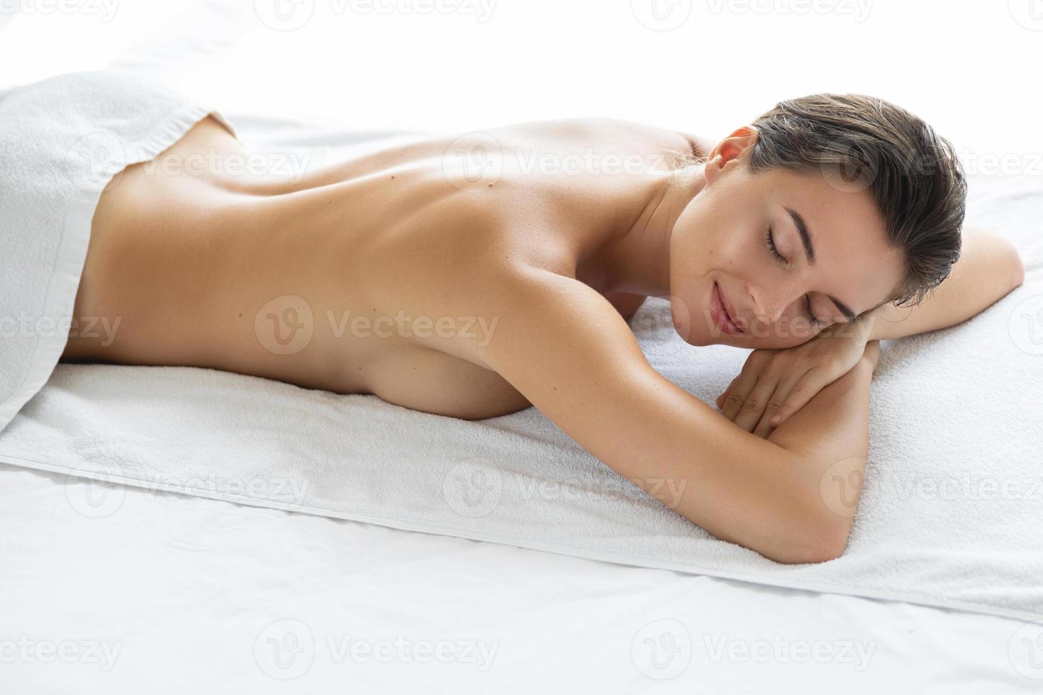 mulher jovem e bonita está mentindo e relaxando após a massagem foto