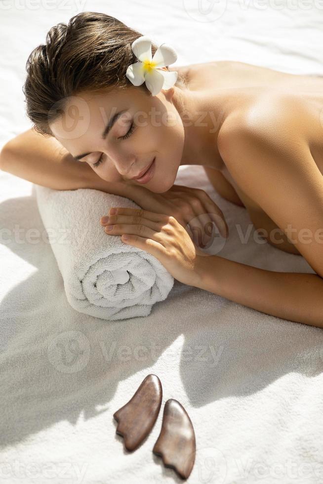 linda mulher está relaxando durante sessão de massagem asiática foto