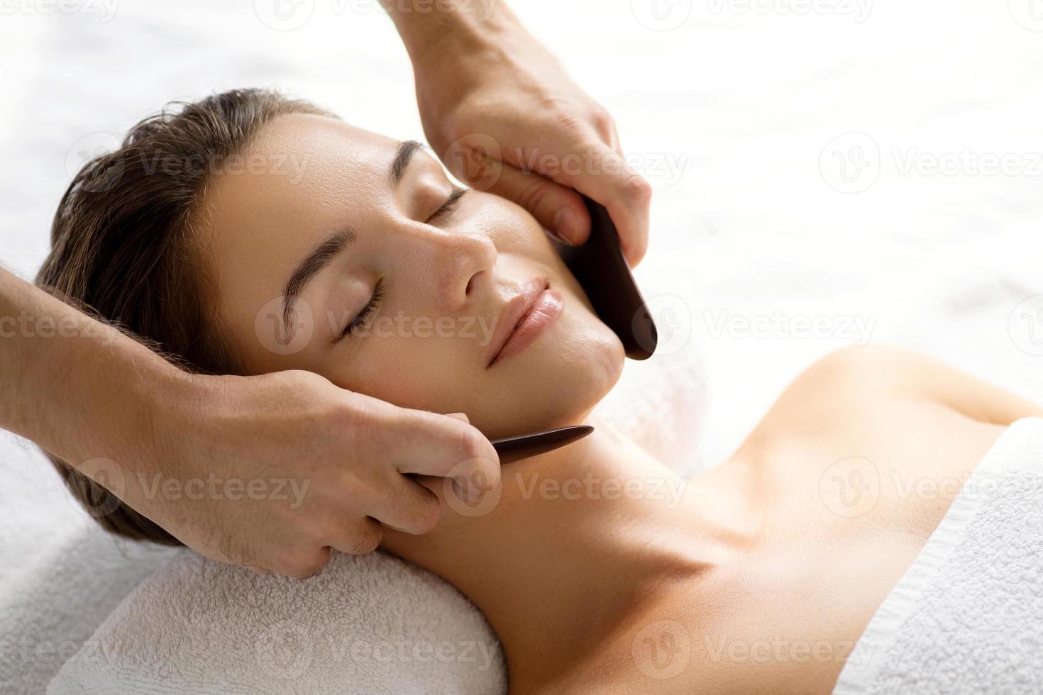 mulher durante massagem tradicional chinesa - gua sha foto