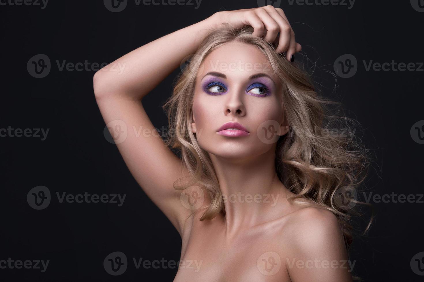 mulher loira com cabelos ondulados e maquiagem colorida foto