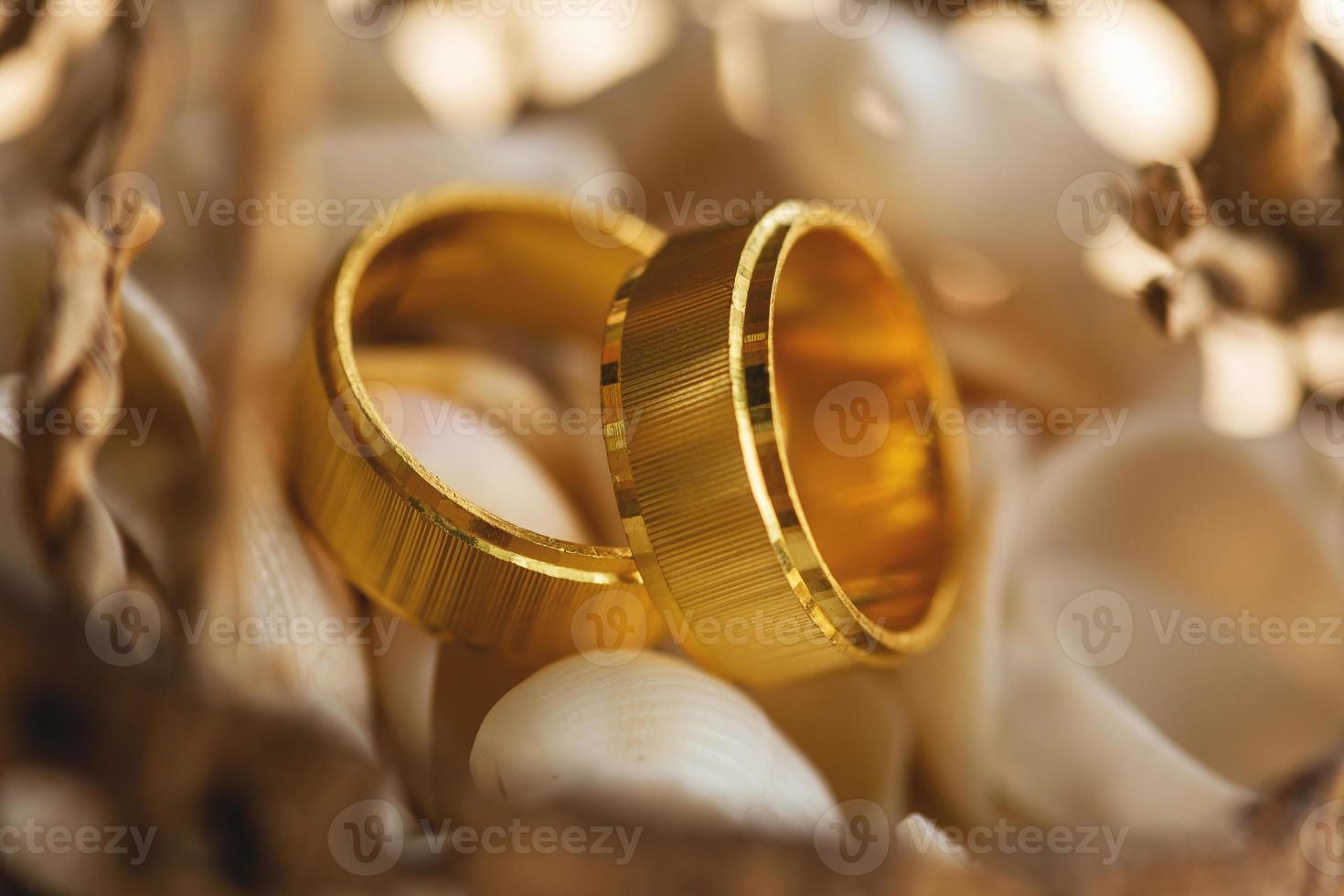 close-up de anéis de casamento dourados dentro de casca de coco foto