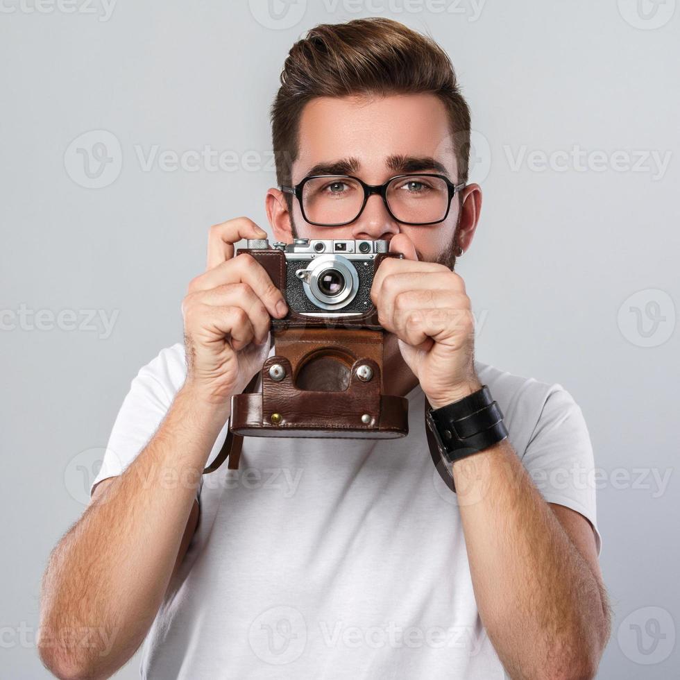homem fotógrafo com câmera retro em estúdio foto