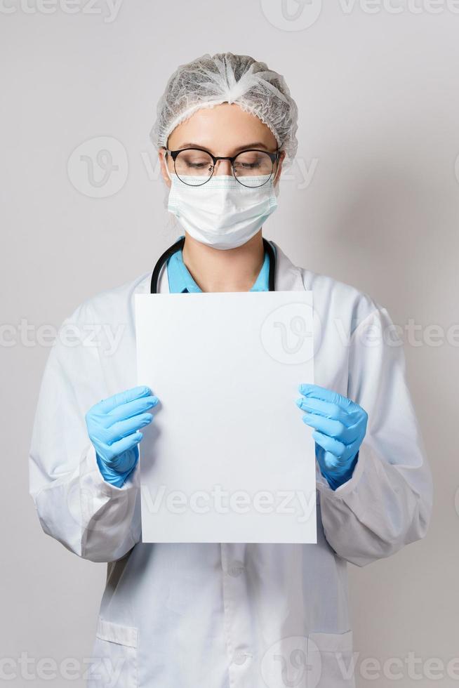 médico está segurando papel está segurando uma folha de papel branco em branco foto