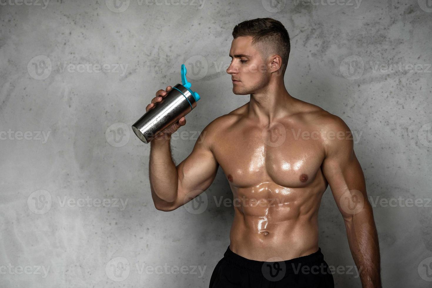 homem musculoso bebendo whey protein ou outro suplemento esportivo foto