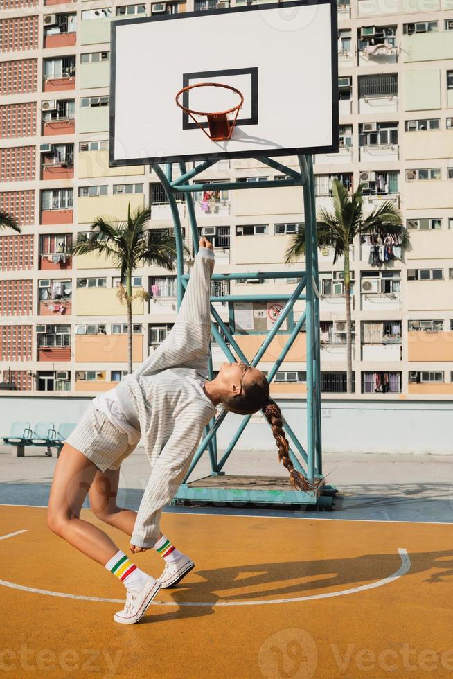 jovem elegante está posando na quadra de basquete Choi Hang Estate foto