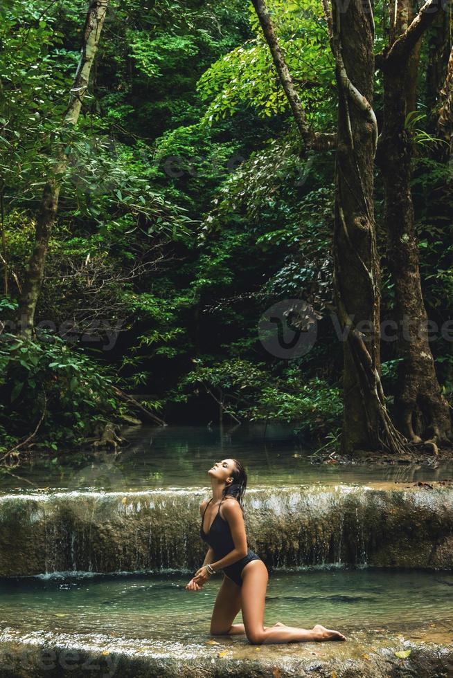 mulher sexy na selva com bela cachoeira foto