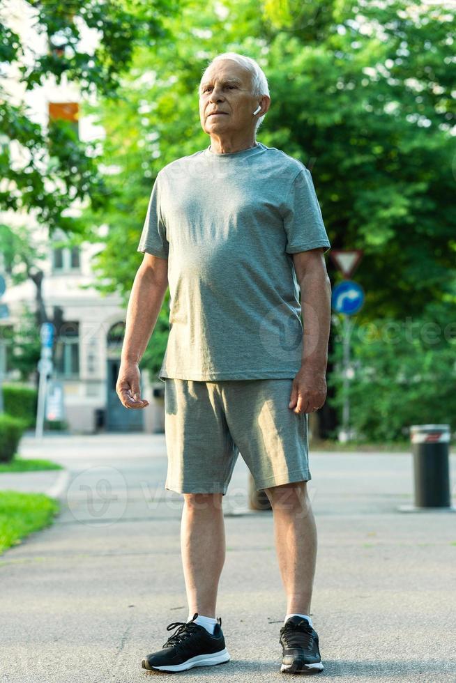 homem idoso durante seu treino de corrida em um parque da cidade foto