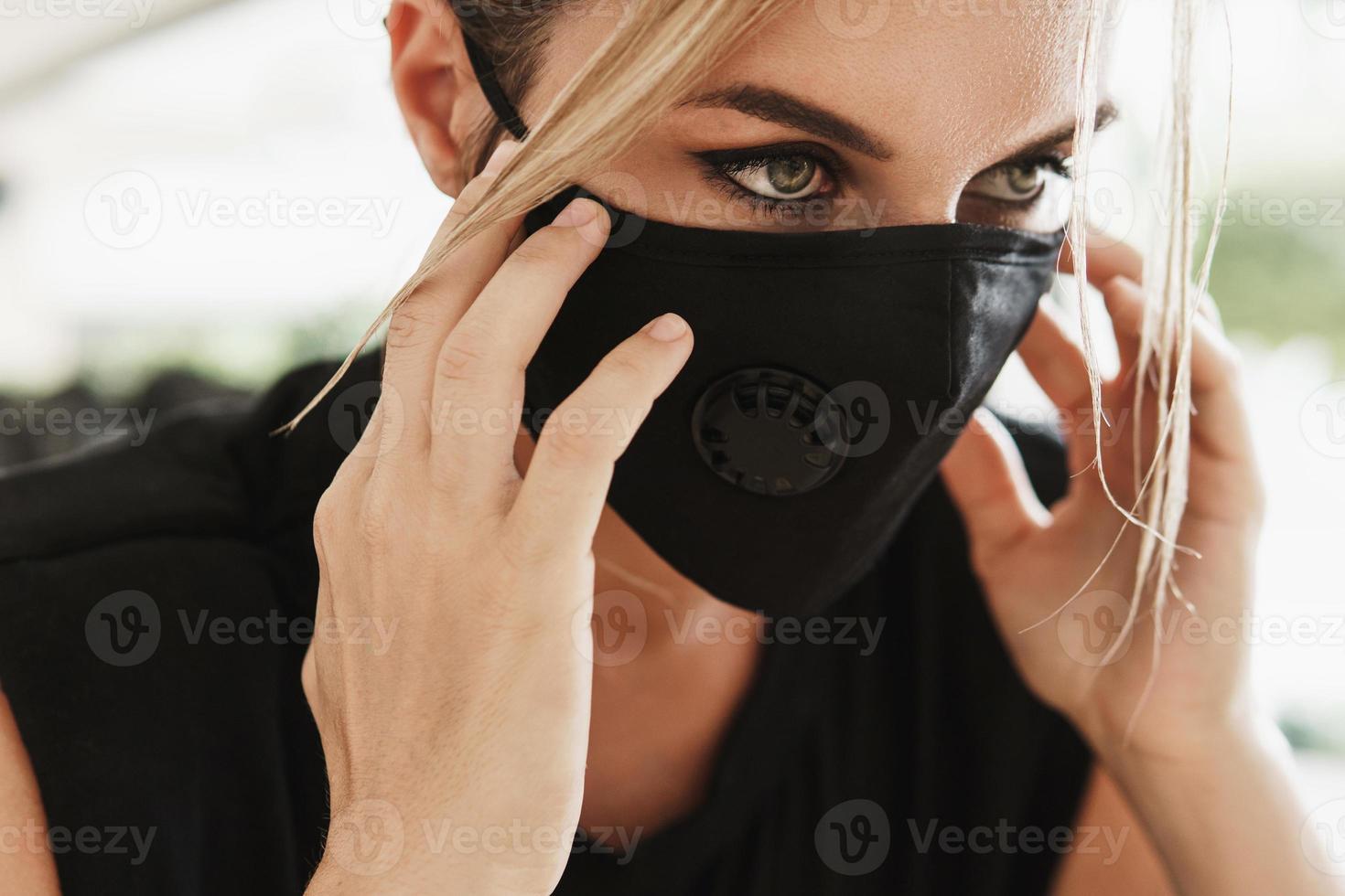 jovem atlética usando uma máscara facial de prevenção durante seu treino de fitness. foto