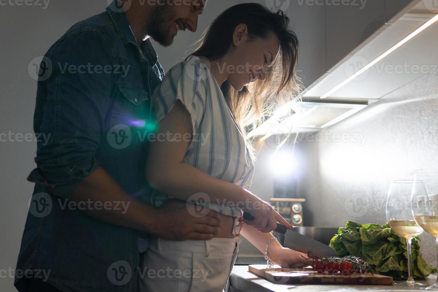 jovem casal cozinhando um saboroso jantar juntos em uma cozinha foto