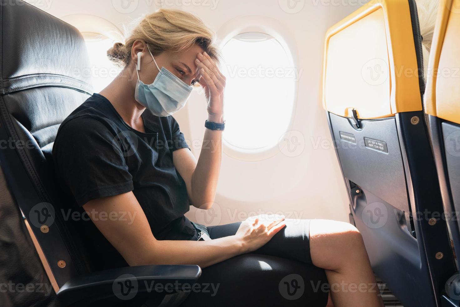 mulher usando máscara de prevenção durante um voo dentro de um avião foto