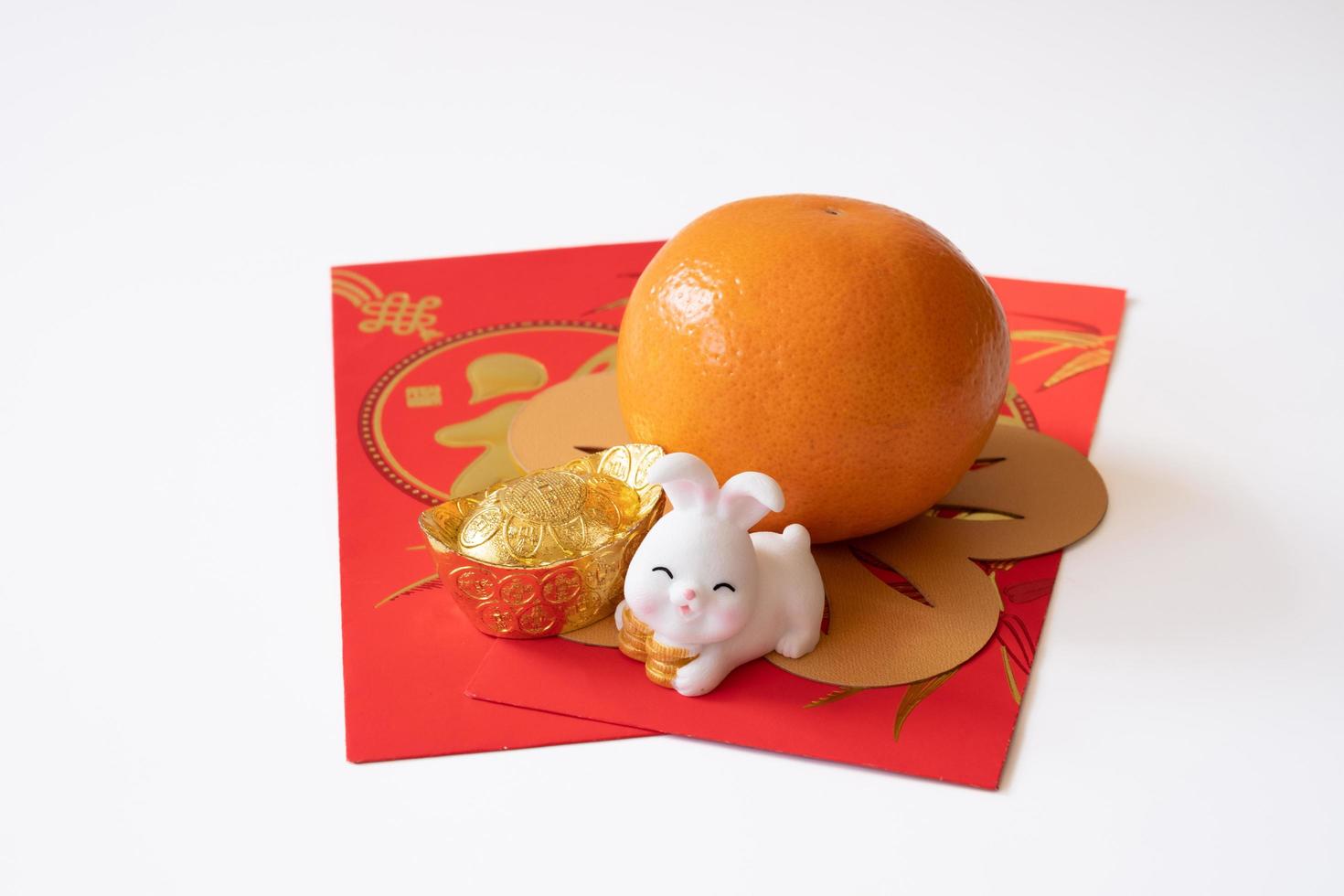 ano novo chinês do conceito de festival de coelho. mandarina, coelho e lingote de ouro isolado no fundo branco. foto