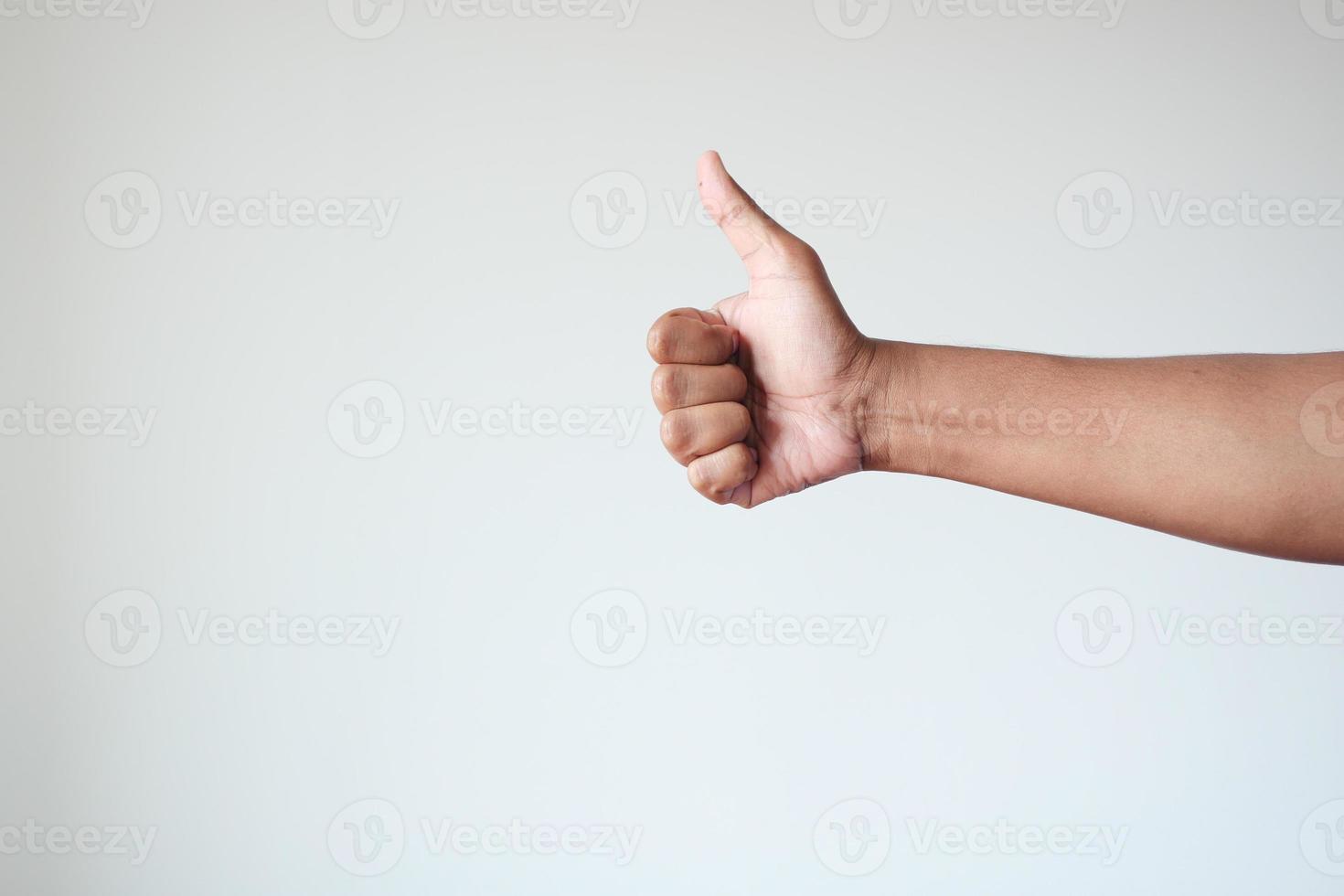 mão de homem mostrando um polegar para cima foto