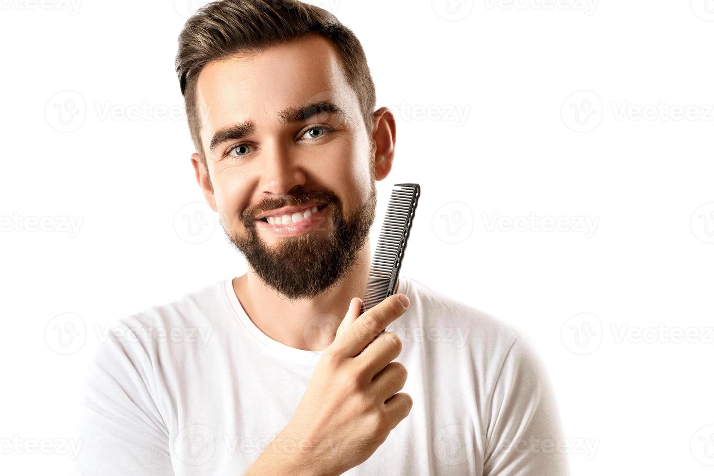 homem bonito e bem preparado, penteando a barba foto