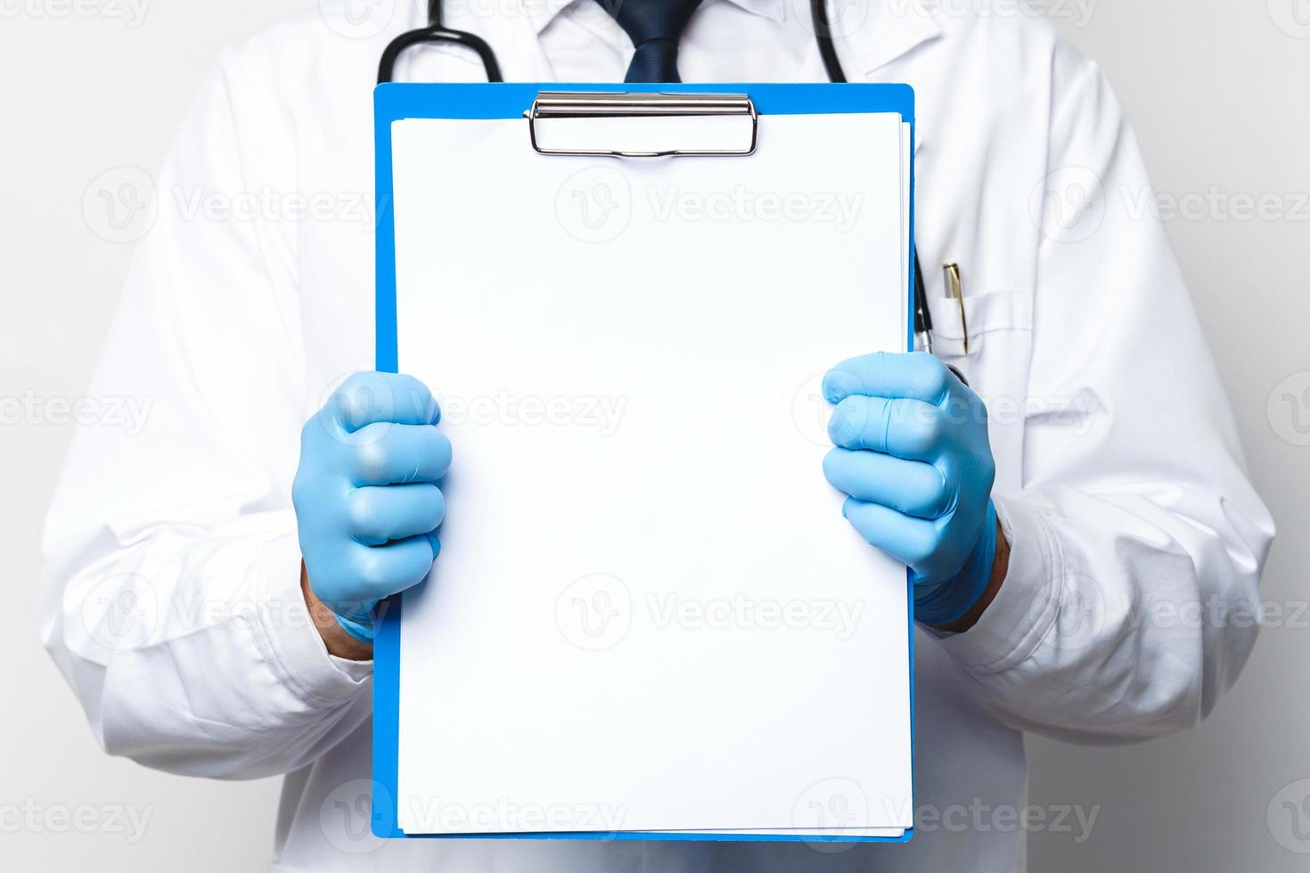 médico está segurando uma prancheta com um papel branco em branco foto