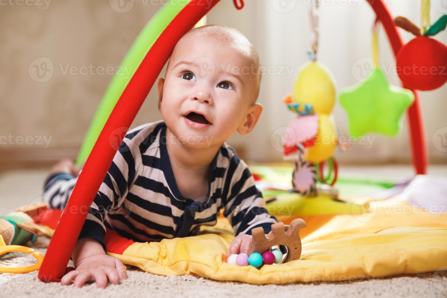 bebê fofo está brincando no tapete de atividades foto