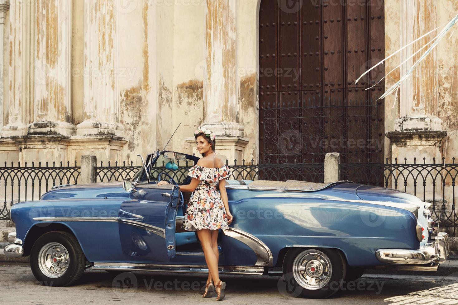 mulher vestindo lindo vestido e carro conversível retrô foto