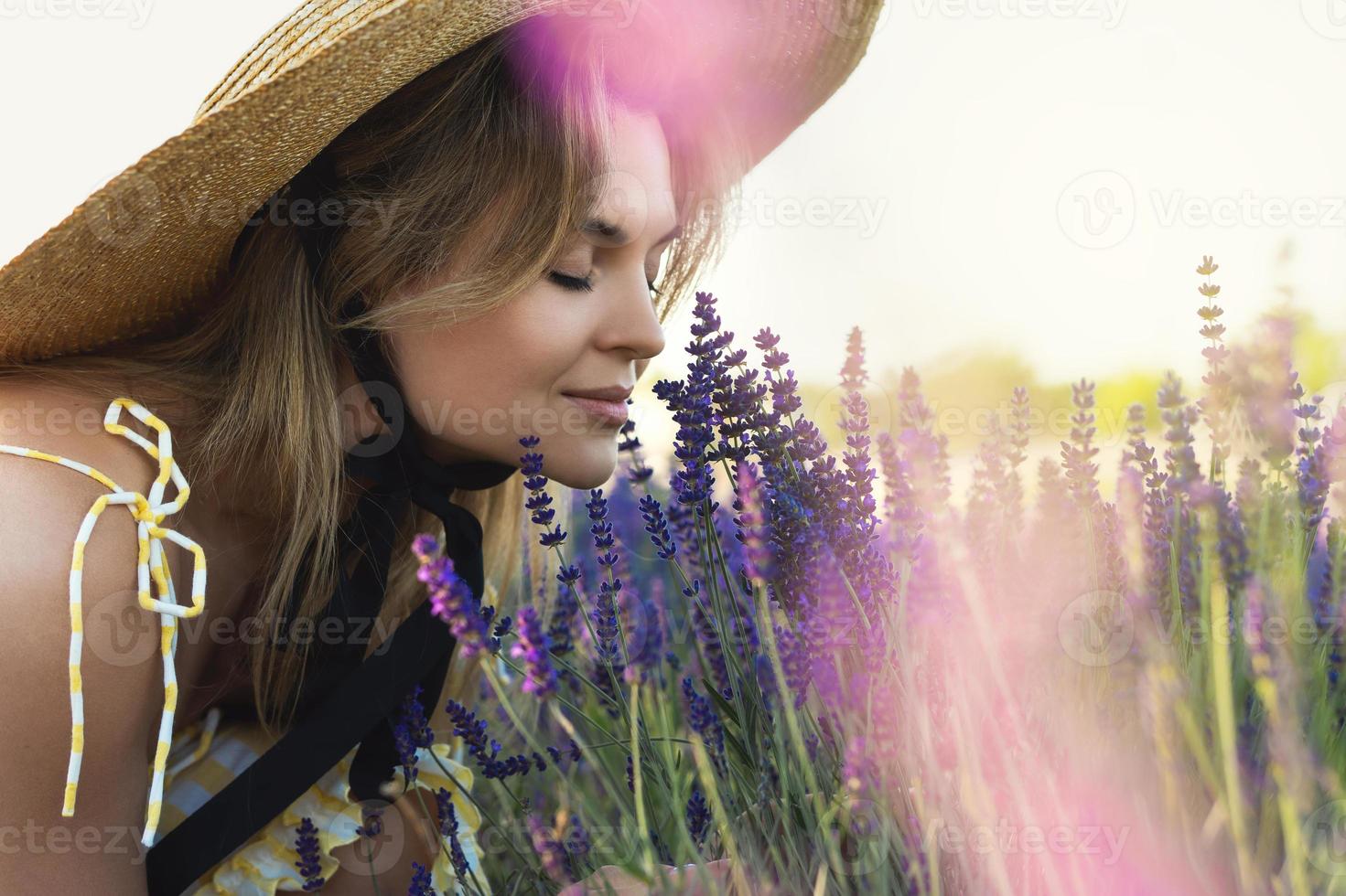 mulher jovem e bonita em um campo cheio de flores de lavanda foto