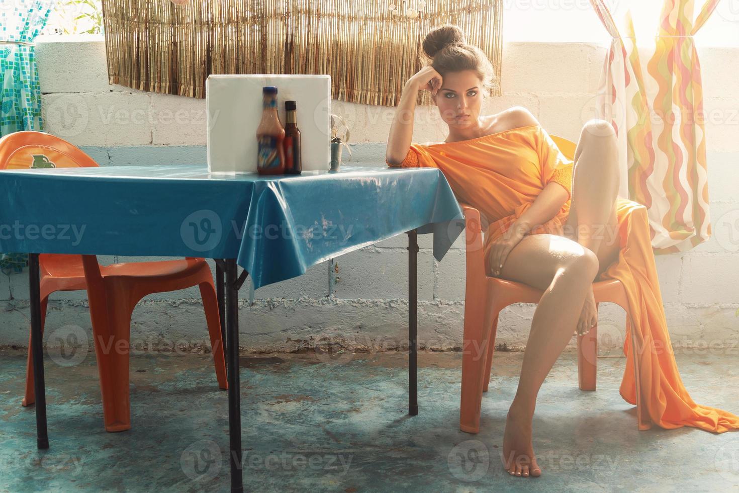 mulher elegante em lindo vestido laranja sentado na antiga cafeteria autêntica foto