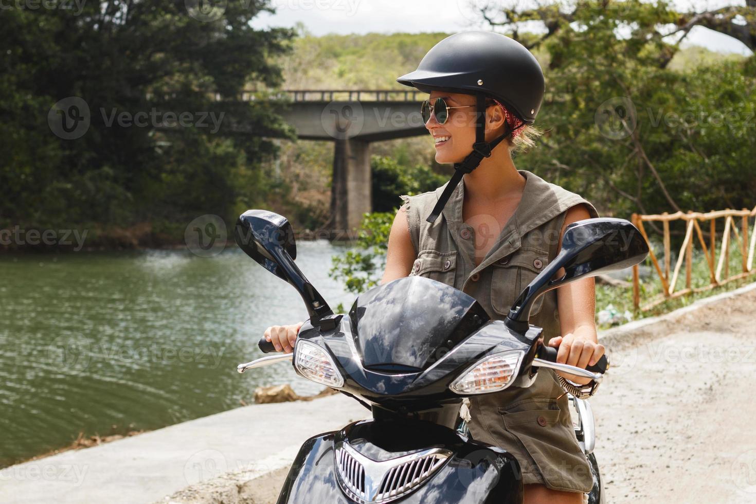 mulher dirigindo scooter na antiga estrada rural nas montanhas foto