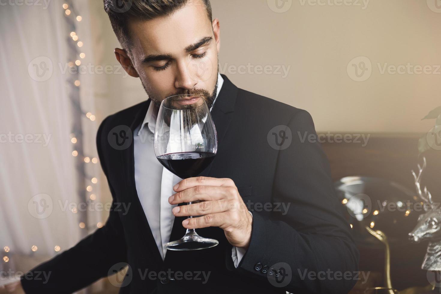 homem barbudo bonito com um copo de vinho tinto foto