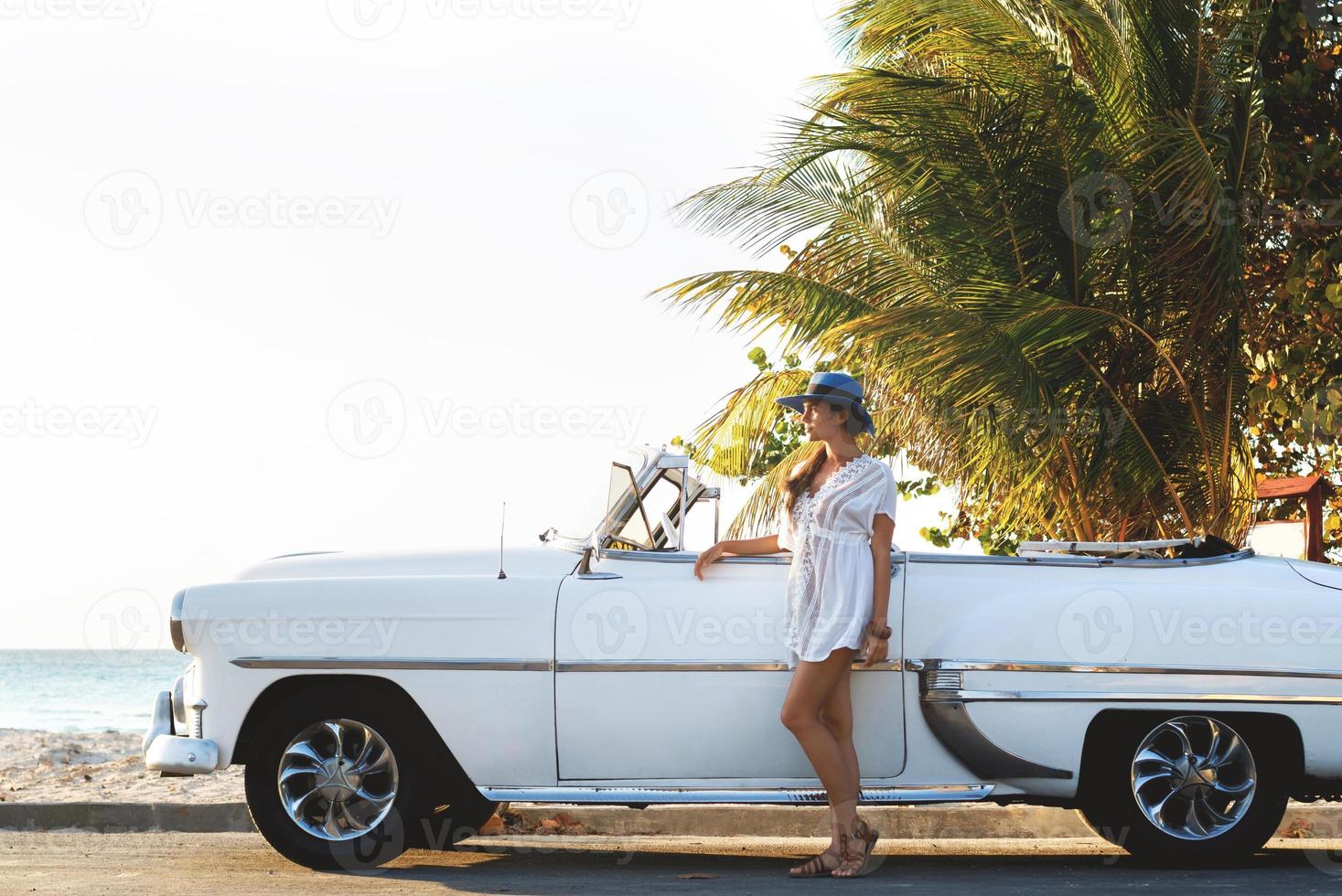 mulher jovem feliz e carro conversível retrô foto