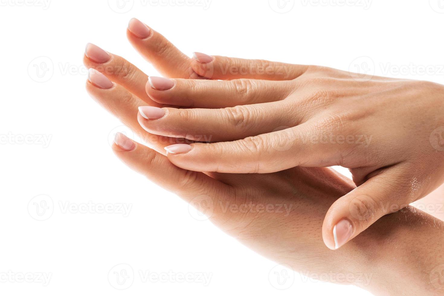 mãos femininas com pele macia e linda manicure francesa em fundo branco foto