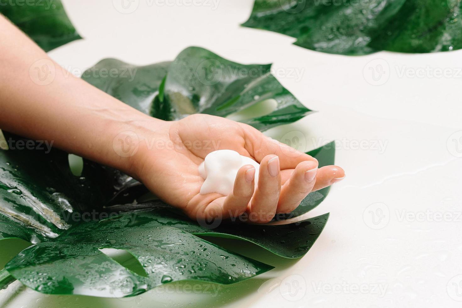 closeup de mão feminina com uma espuma de limpeza foto