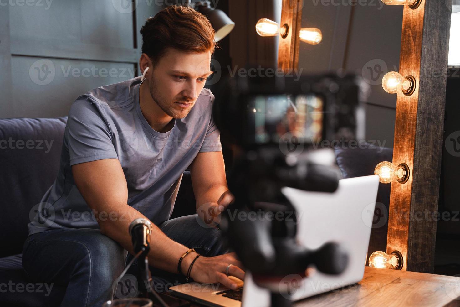 jovem blogueiro está trabalhando em seu laptop foto