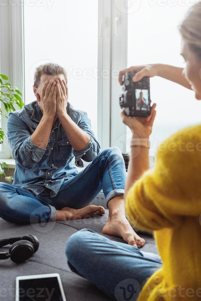 fotógrafo de mulher tirando fotos de seu namorado em casa