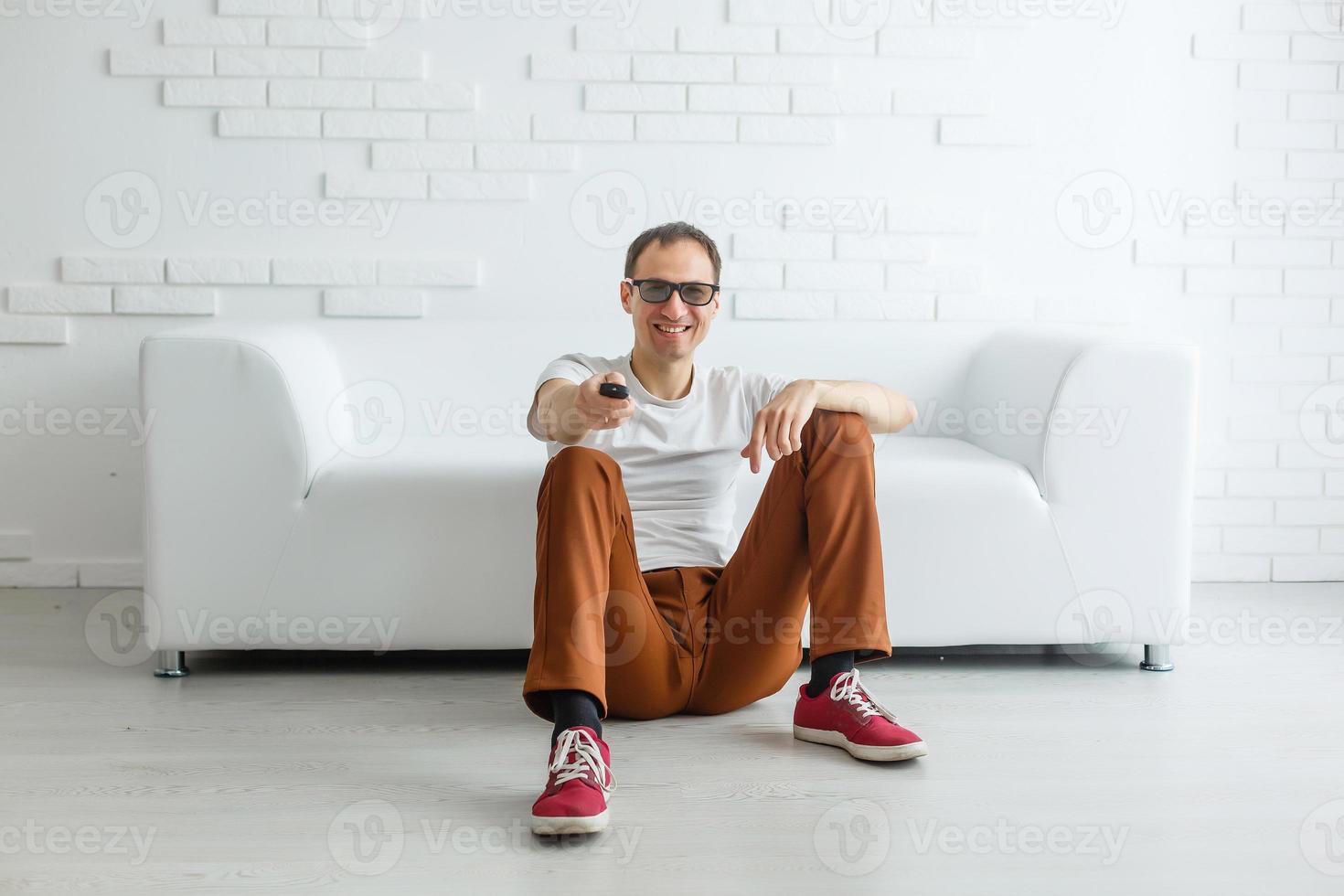 homem maduro sentado no sofá assistindo televisão foto