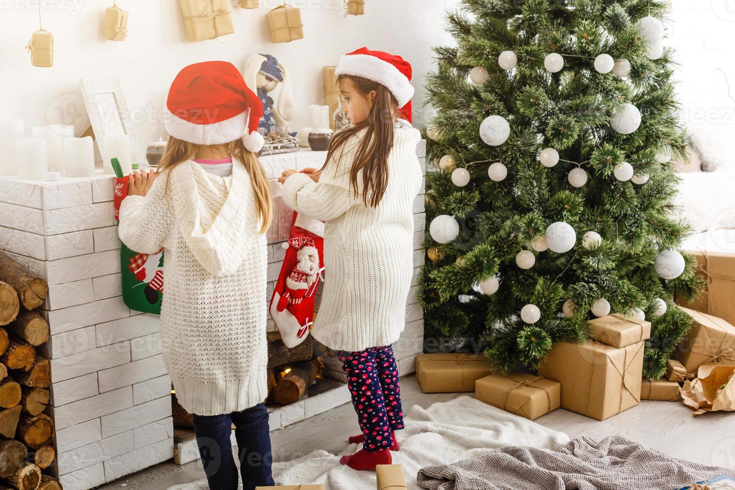 crianças irmãzinhas seguram fundo interior de caixas de presentes. que grande surpresa. pequenas garotas bonitas receberam presentes de feriado. melhores brinquedos e presentes de natal. amigos de crianças animados desembalando seus presentes. foto