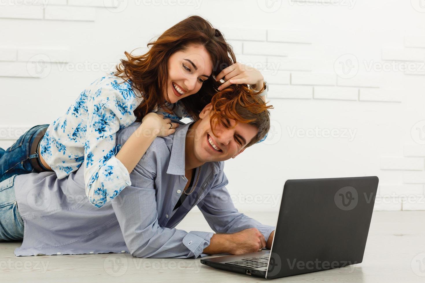 casal comprando online junto com um laptop em um desktop em casa foto