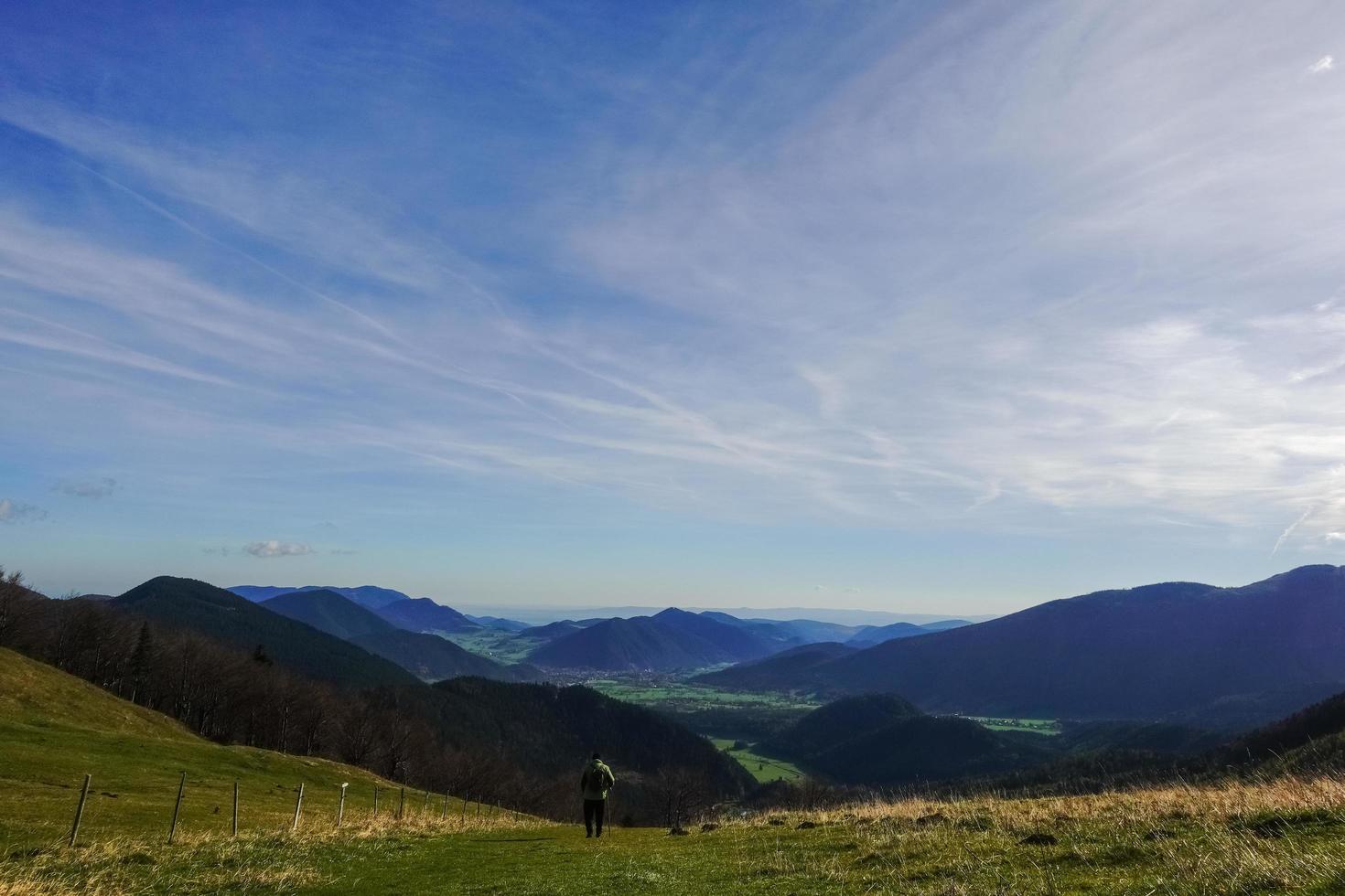 alpinista único em um prado descendo a colina nas montanhas foto