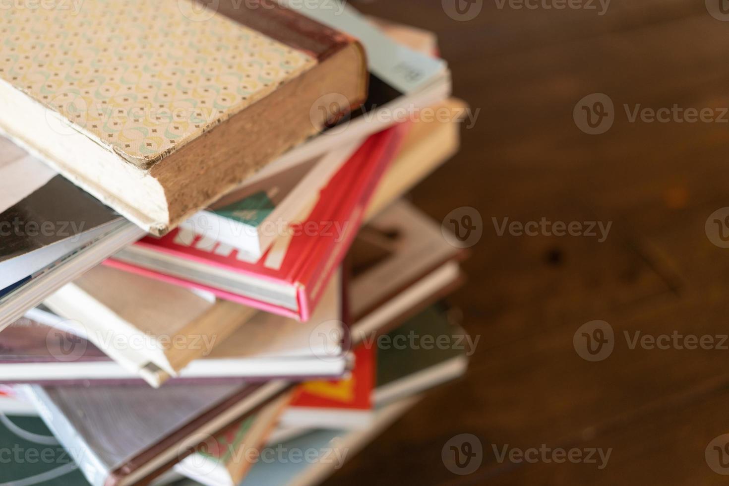 empilhe livros ou livros didáticos na mesa de madeira na sala. pesquisa de literatura. pesquisa de informações de conceito em livros. de volta à escola. conceito de educação e escola. copie o espaço. foco seletivo. foto