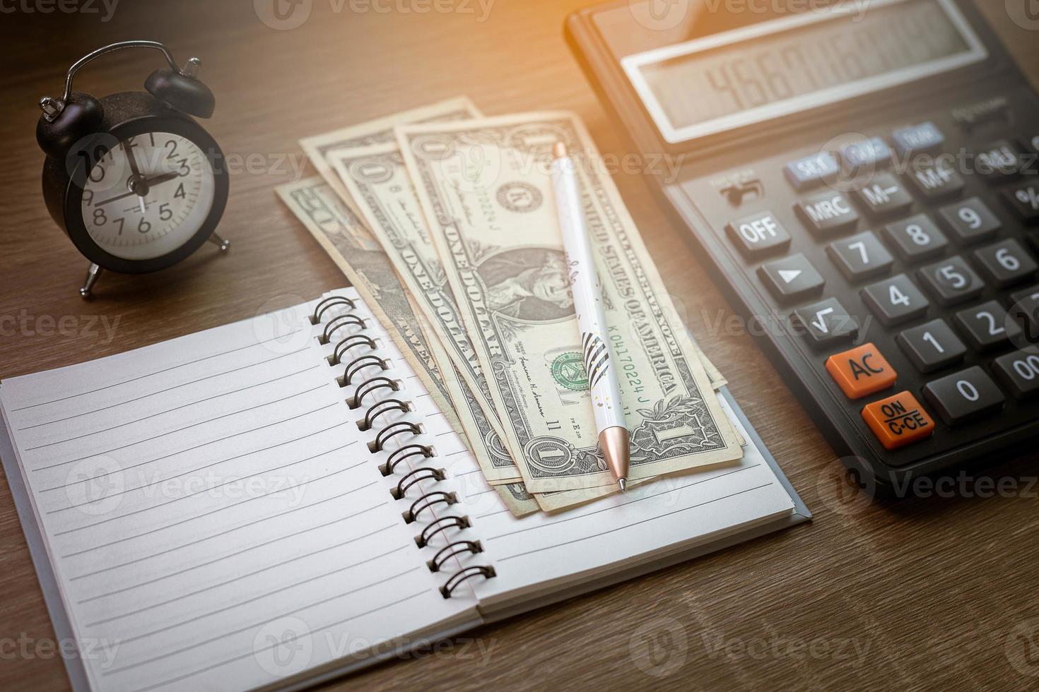 cadernos, canetas, relógios e calculadoras na mesa de madeira elementos computacionais finanças empresariais despesas de tempo foto