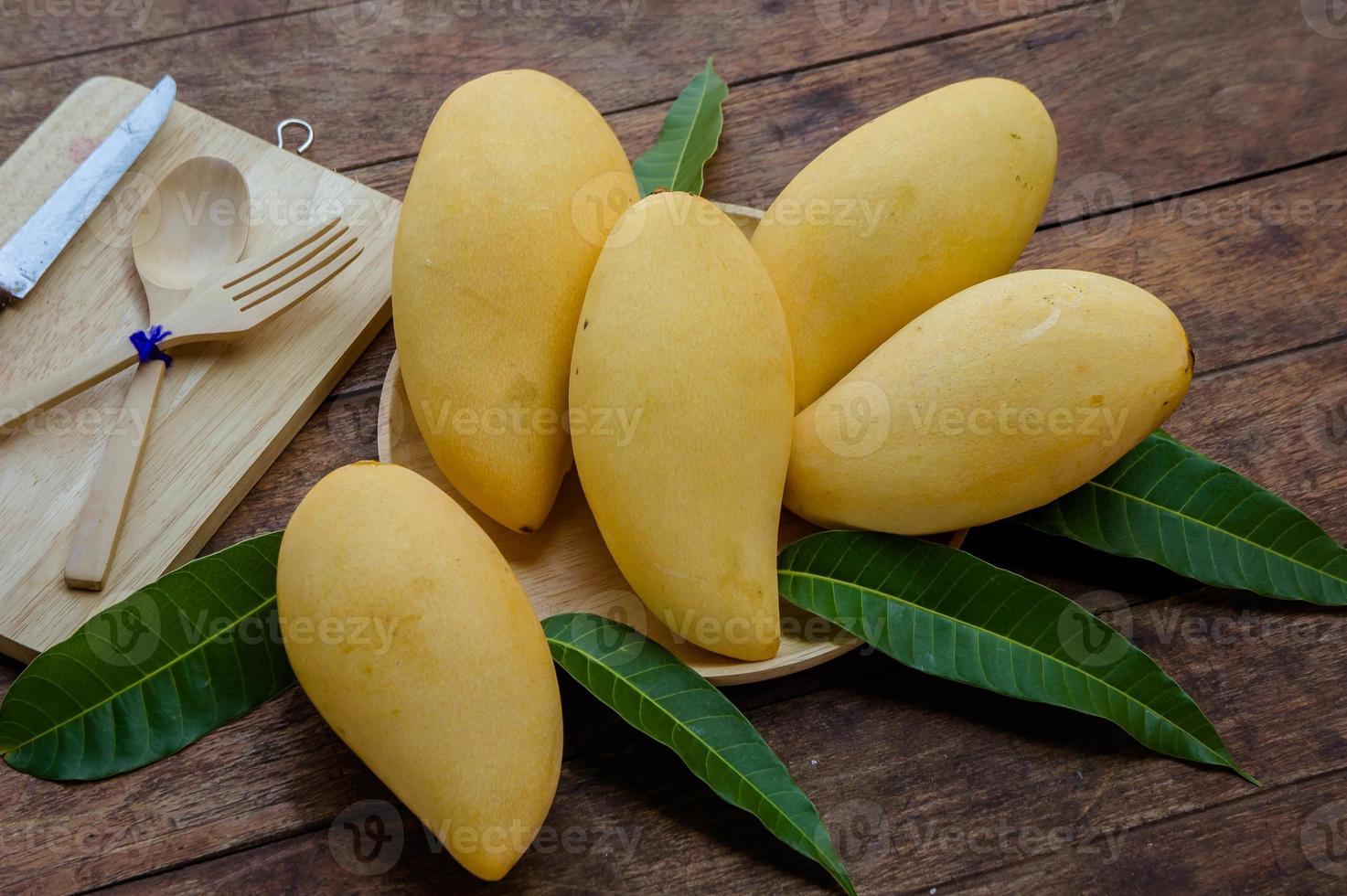 fruta doce manga amarela na mesa de madeira, pronta para comer saudável, fruta no verão foto