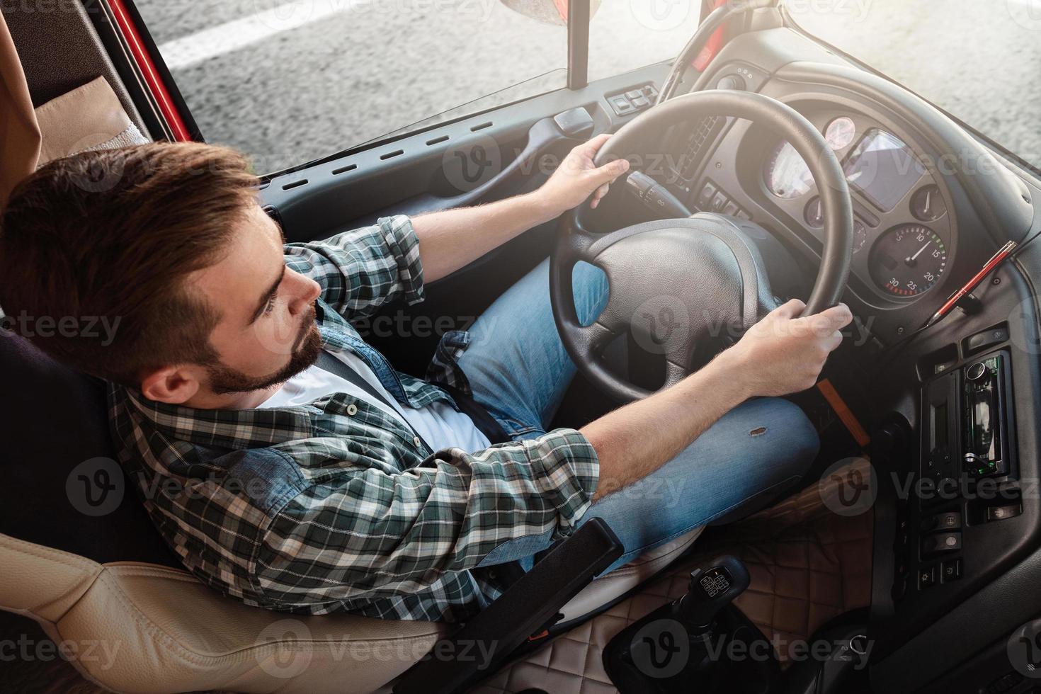 motorista de caminhão masculino dirigindo seu grande veículo foto