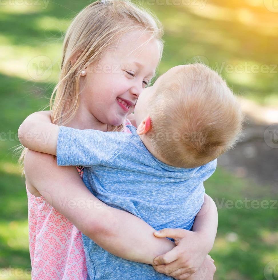 jovem irmão e irmã abraçando no parque foto