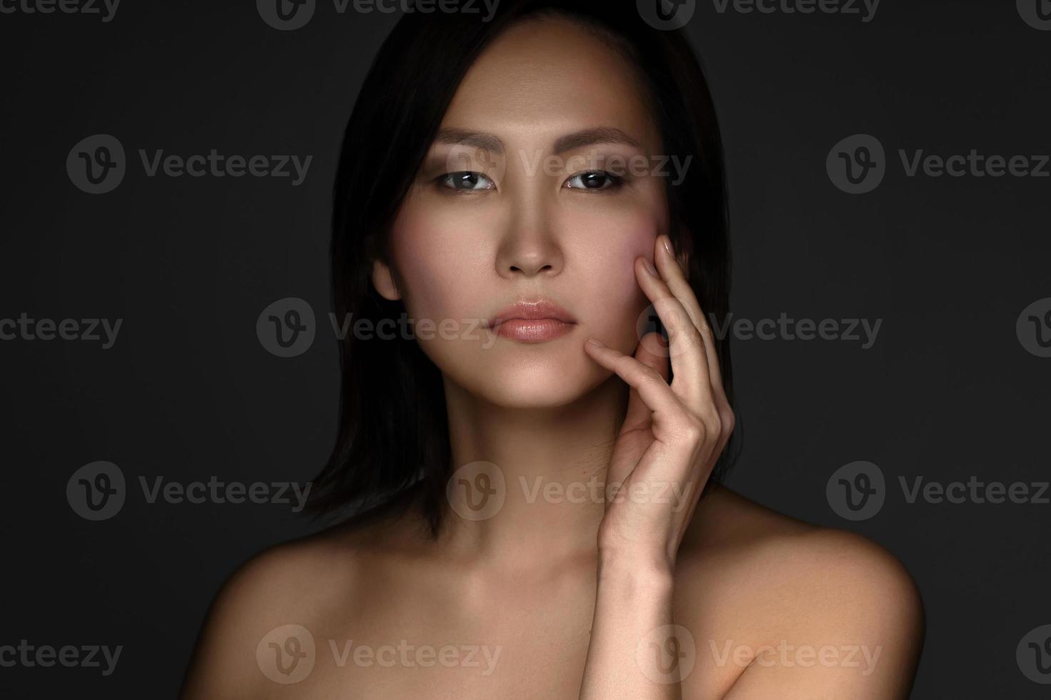 retrato de jovem e bela mulher asiática em fundo cinza foto