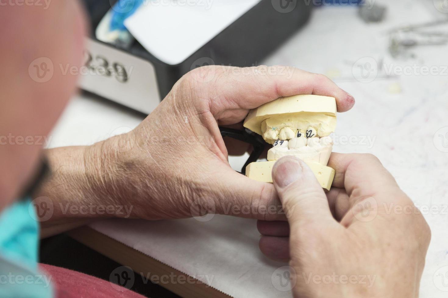 técnico dentário trabalhando em molde impresso em 3D para implantes dentários foto