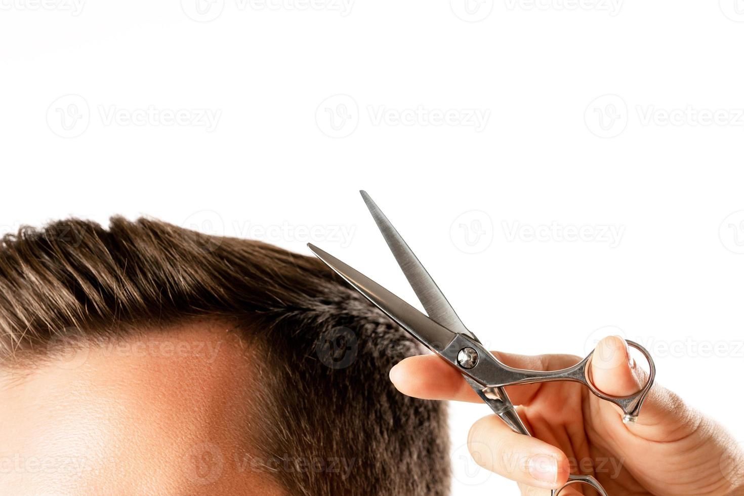 mão de cabeleireiro com tesoura e cabelo de homem foto